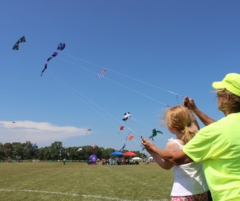 Young girl and grandmother flying a kite together