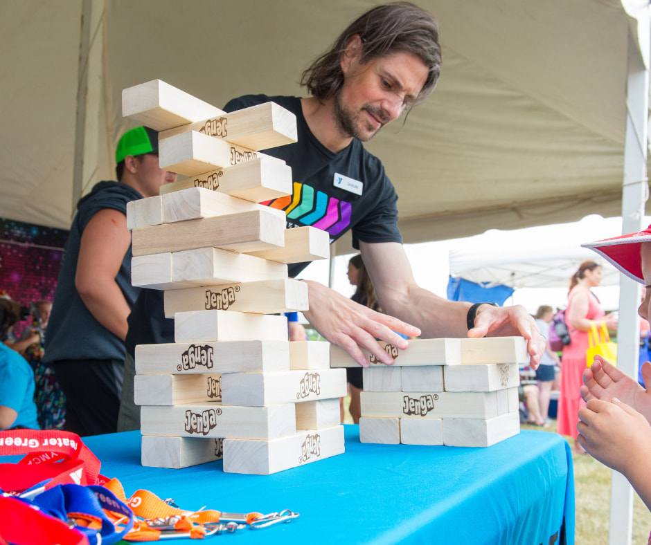 YMCA team member setting up a Jenga game on table